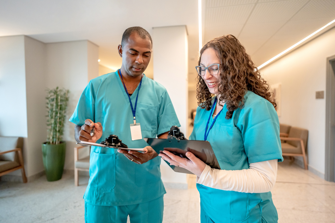 Nurse and male nurse talking in hospital corridor